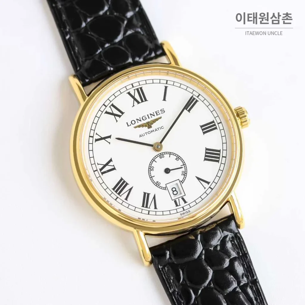 론진 엘레강스 스틸 화이트다이얼 로만인덱스 스몰세컨즈 오토매틱 38.5mm 블랙 가죽 스트랩 골드 베젤