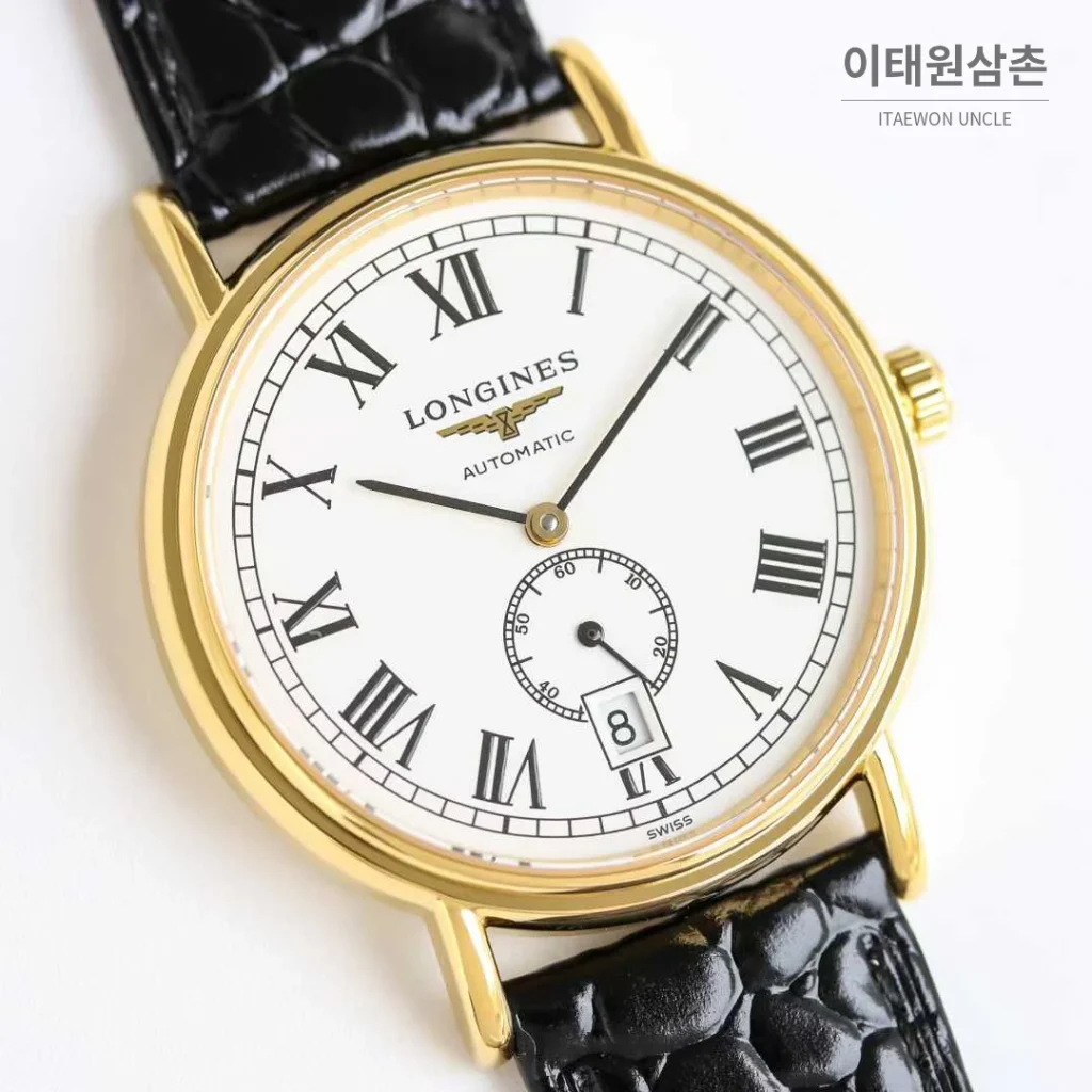 론진 엘레강스 스틸 화이트다이얼 로만인덱스 스몰세컨즈 오토매틱 38.5mm 블랙 가죽 스트랩 골드 베젤