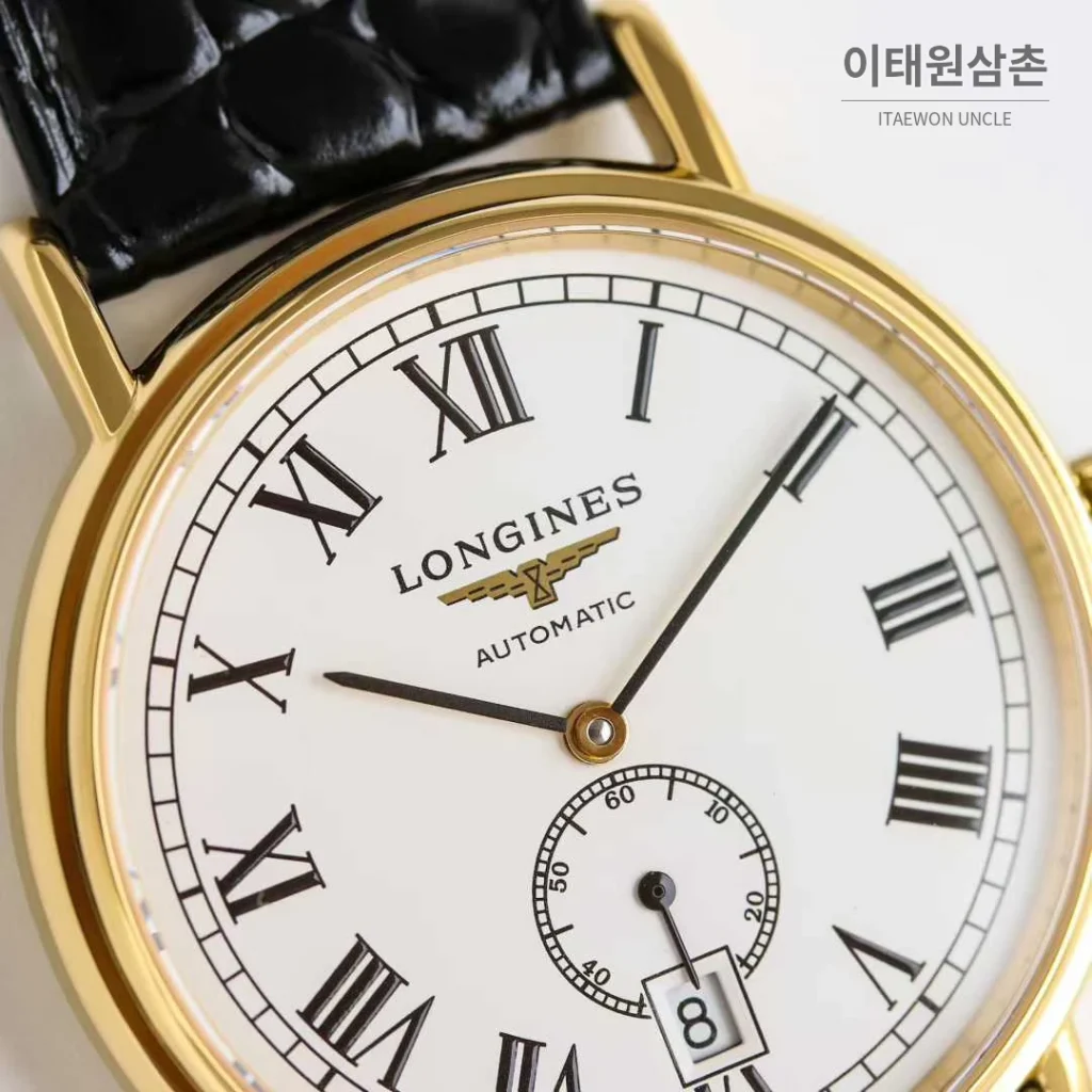 론진 엘레강스 스틸 화이트다이얼 로만인덱스 스몰세컨즈 오토매틱 38.5mm 블랙 가죽 스트랩 골드 베젤