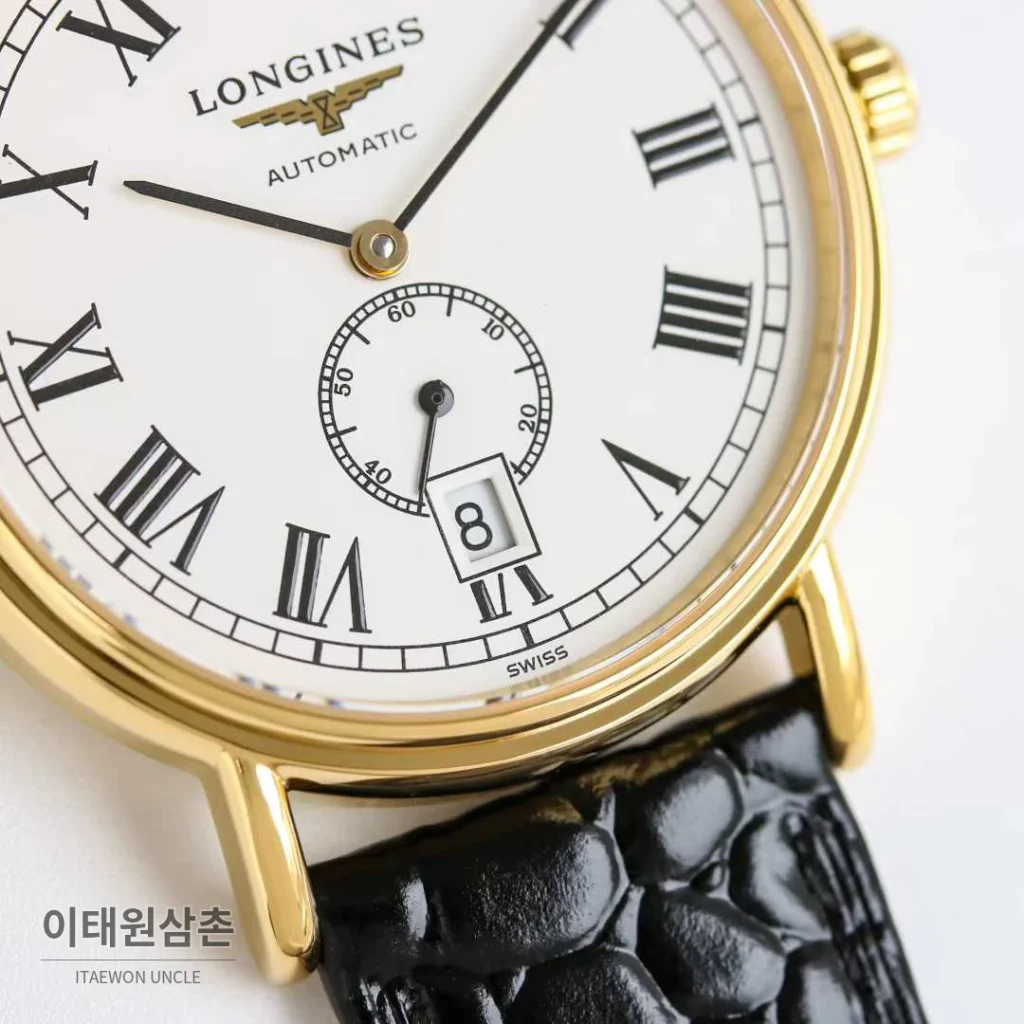 론진 엘레강스 스틸 화이트다이얼 로만인덱스 스몰세컨즈 오토매틱 38.5mm 블랙 가죽 스트랩 골드 베젤